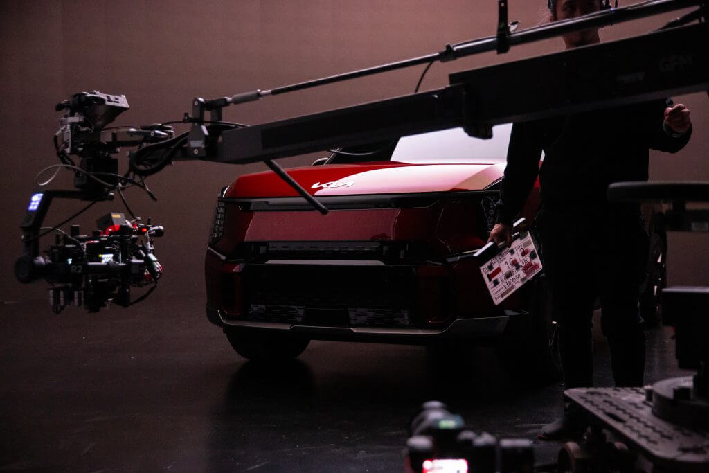 FX Productions Canada A red car is positioned in a studio with a camera rig and crew members from FX Productions Canada nearby, preparing for a video or photo shoot. Toronto Video Production Company