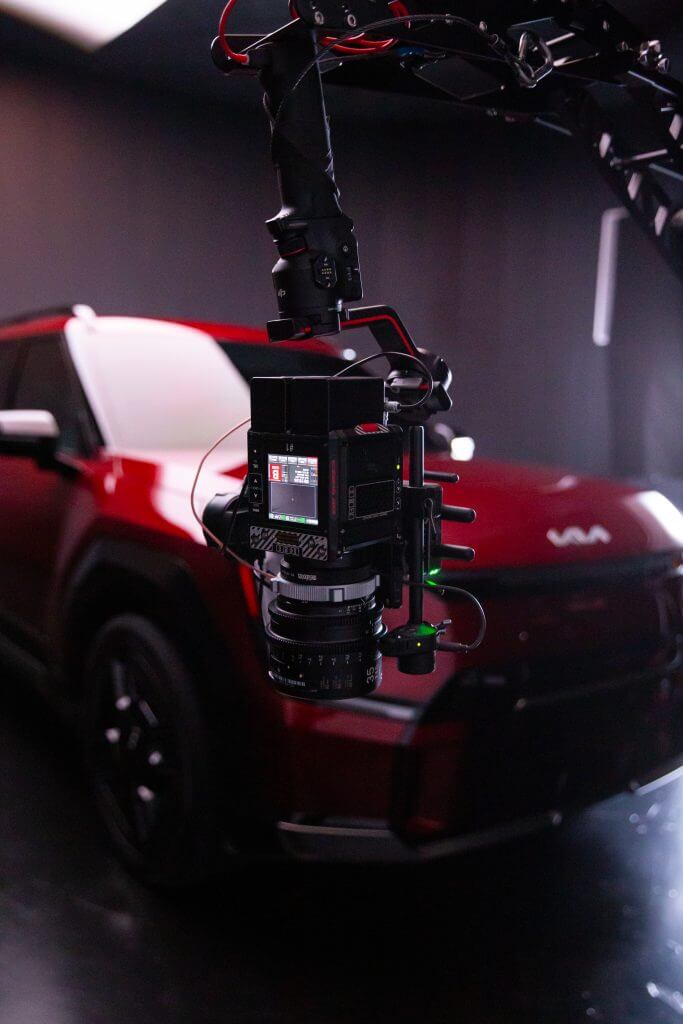 FX Productions Canada A professional camera rig is suspended in front of a red Kia car inside a studio with dark lighting, showcasing the expertise of FX Productions Canada, a leading Toronto Video Production company. Toronto Video Production Company
