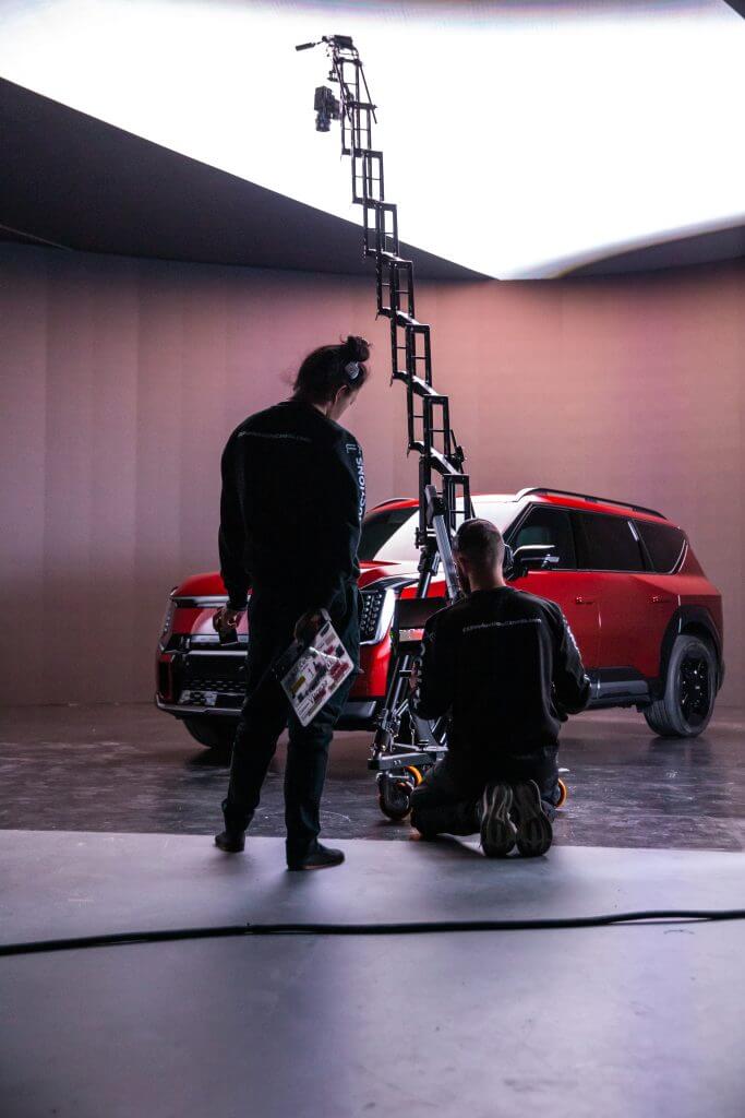 FX Productions Canada Two people operate a camera crane in a studio, filming a red SUV under professional lighting for FX Productions Canada, a leading Toronto Video Production company. Toronto Video Production Company