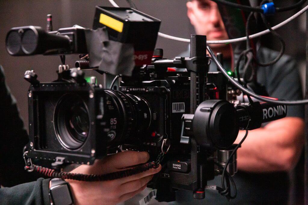 FX Productions Canada A person operates a professional digital cinema camera rig with various attachments, capturing high-quality footage for a Toronto Video Production project in an indoor setting. Toronto Video Production Company