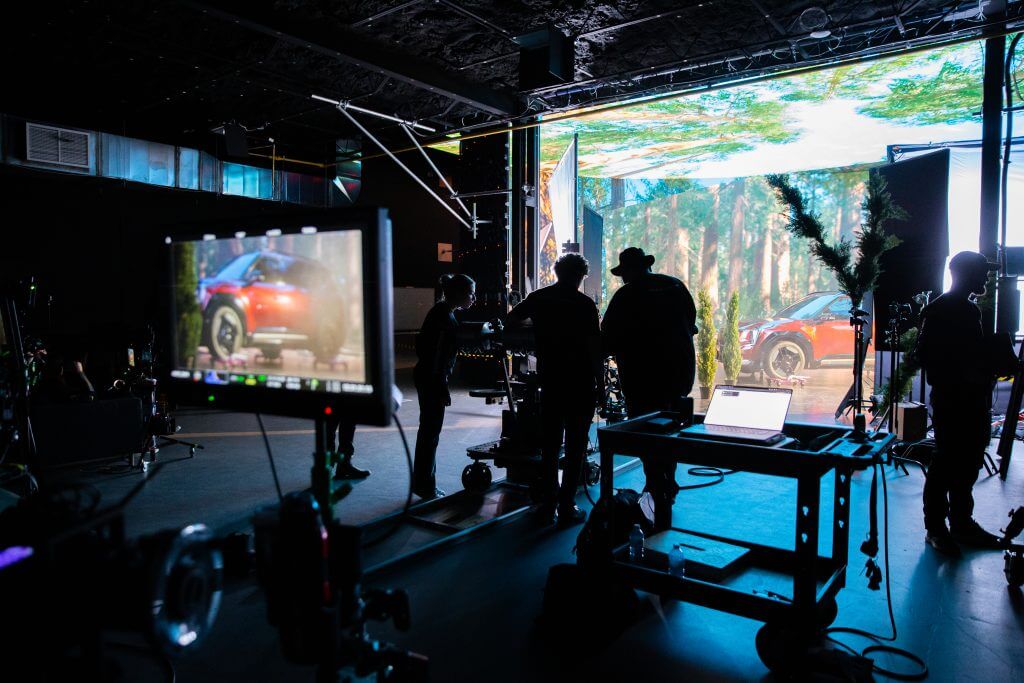 FX Productions Canada A film crew works on set with a car and forest scene displayed on a large screen, while equipment and monitors are visible in the foreground at FX Productions Canada, a leading Toronto Video Production company. Toronto Video Production Company
