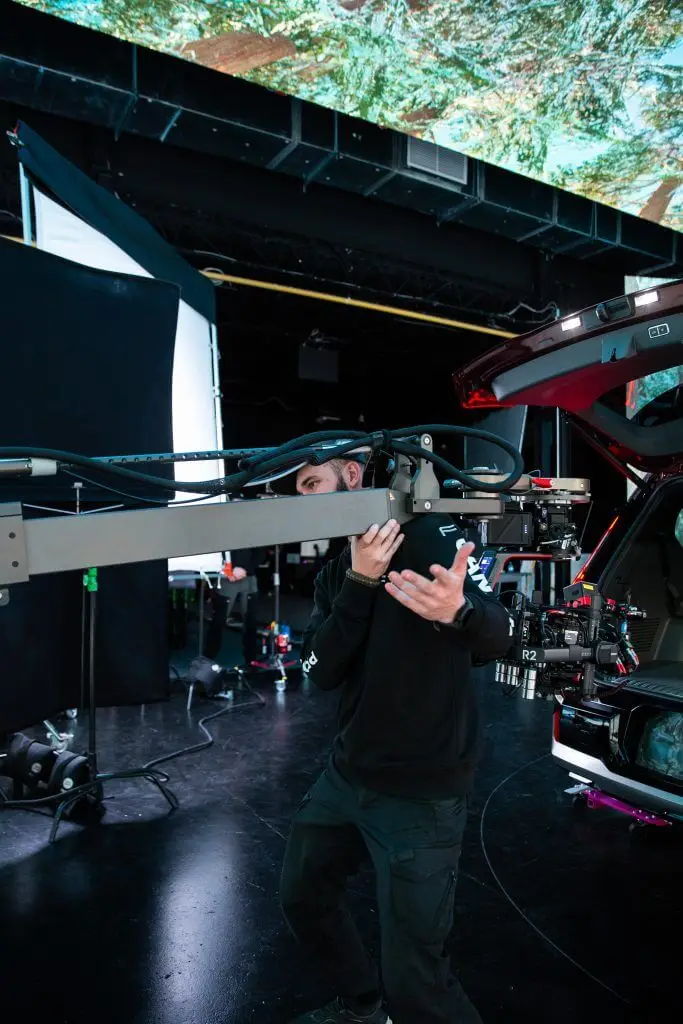 FX Productions Canada A person operates a large camera rig next to a vehicle in a studio, with lighting and equipment visible in the background—showcasing the expertise of FX Productions Canada, a leading Toronto Video Production company. Toronto Video Production Company