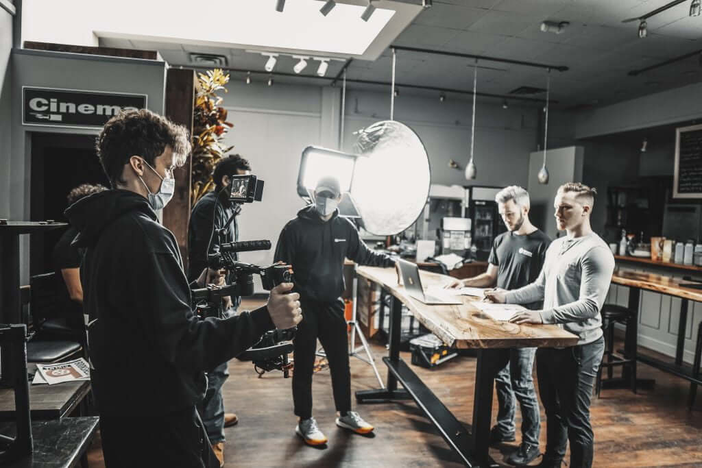 FX Productions Canada A film crew from FX Productions Canada records two men standing at a counter, using professional lights and camera equipment in a Toronto studio setting. Toronto Video Production Company