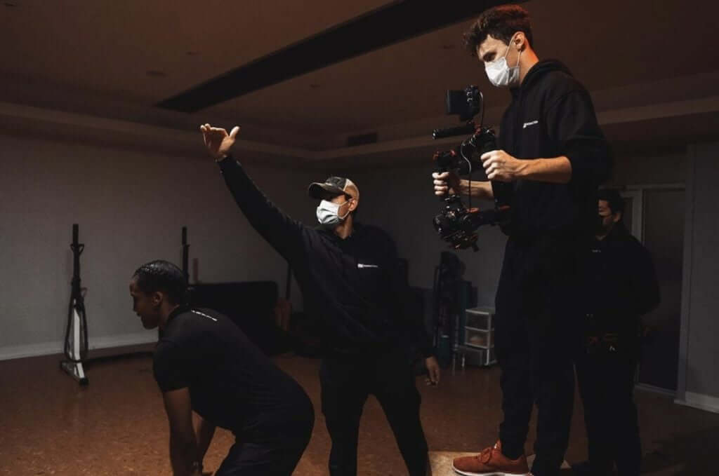FX Productions Canada Three people wearing masks are on a film set; one directs with a raised hand, another operates a camera, and the third prepares for a scene for FX Productions Canada, a leading Toronto video production company. Toronto Video Production Company