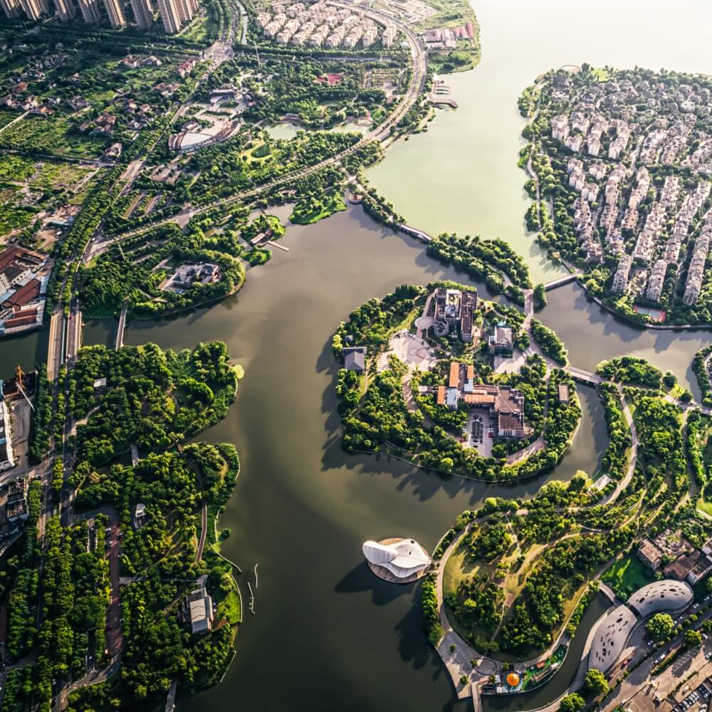 FX Productions Canada Aerial view of a city park with multiple lakes, green spaces, clustered buildings, and curved roads surrounded by water—captured by FX Productions Canada, a leading video production company. Toronto Video Production Company