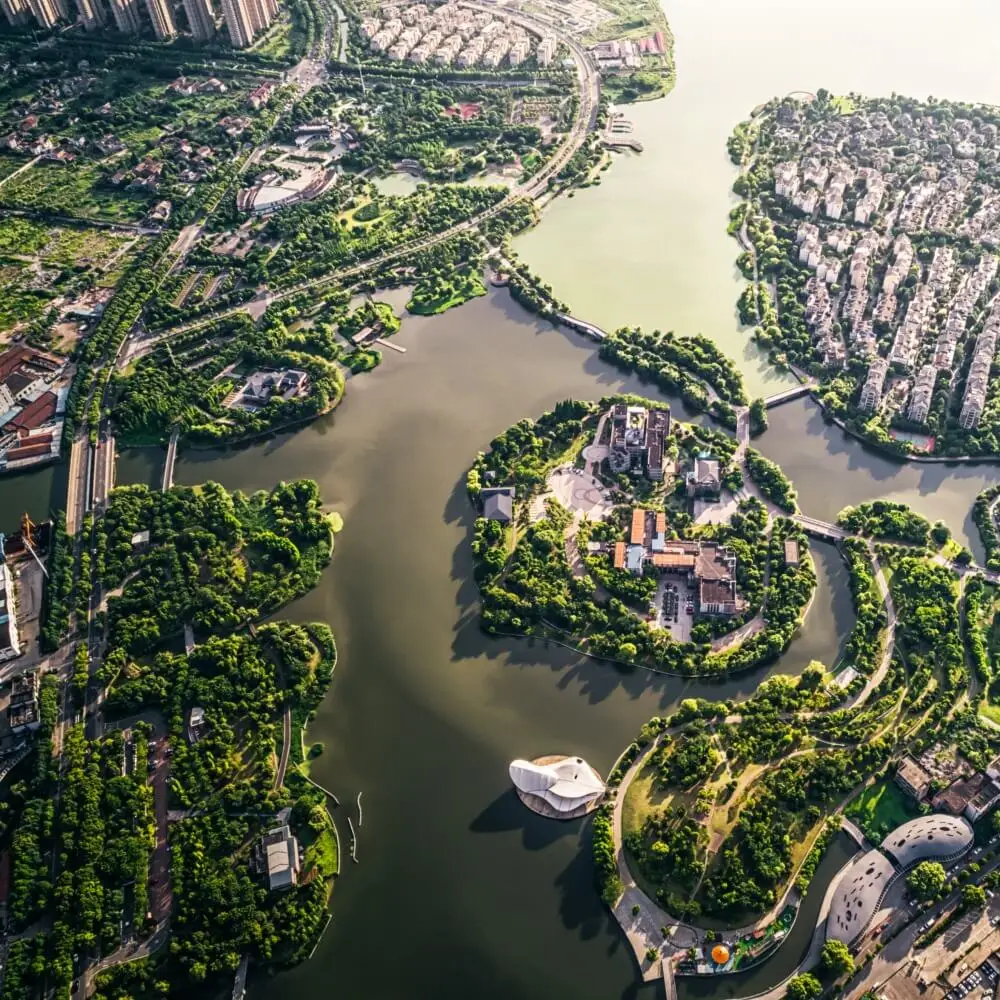 FX Productions Canada Aerial view of a city park with multiple lakes, green spaces, clustered buildings, and curved roads surrounded by water—captured by FX Productions Canada, a leading video production company. Toronto Video Production Company