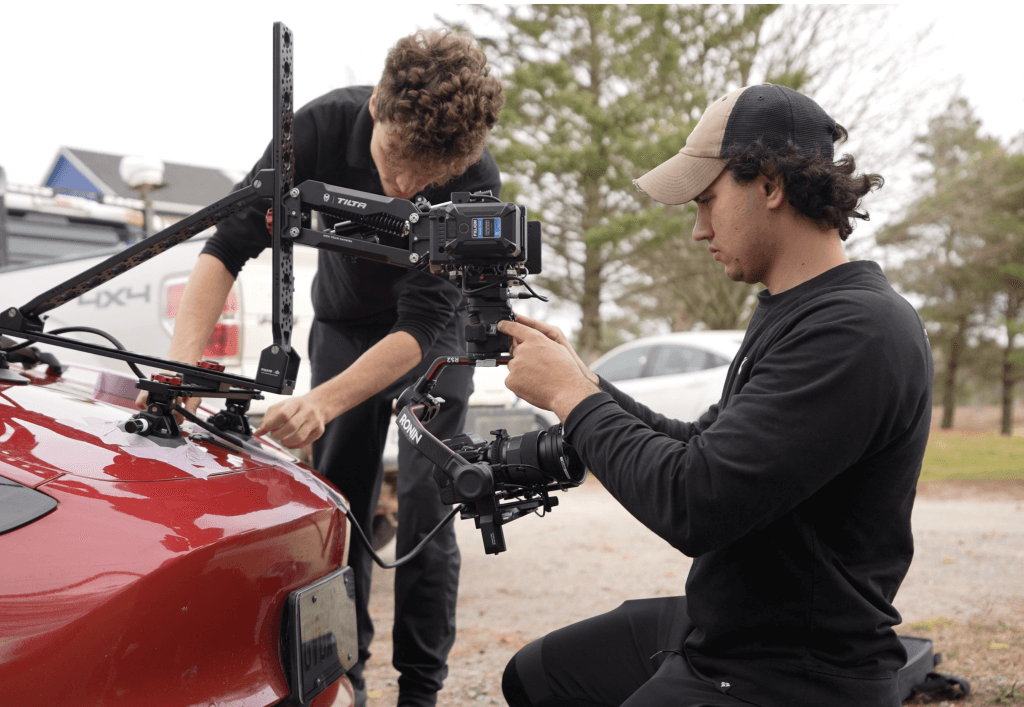 two cameramen in black shirts making video of lambo