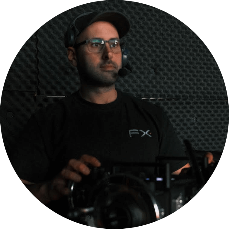 A man in glasses and a black shirt sitting in front of a camera, ready for a video conference.