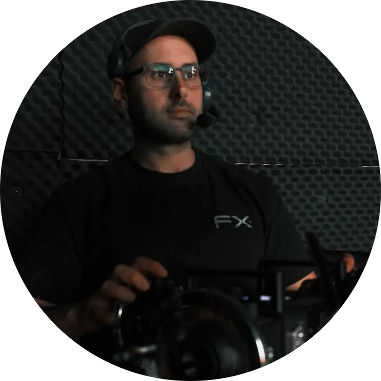 A man in glasses and a black shirt sitting in front of a camera, ready for a video conference.