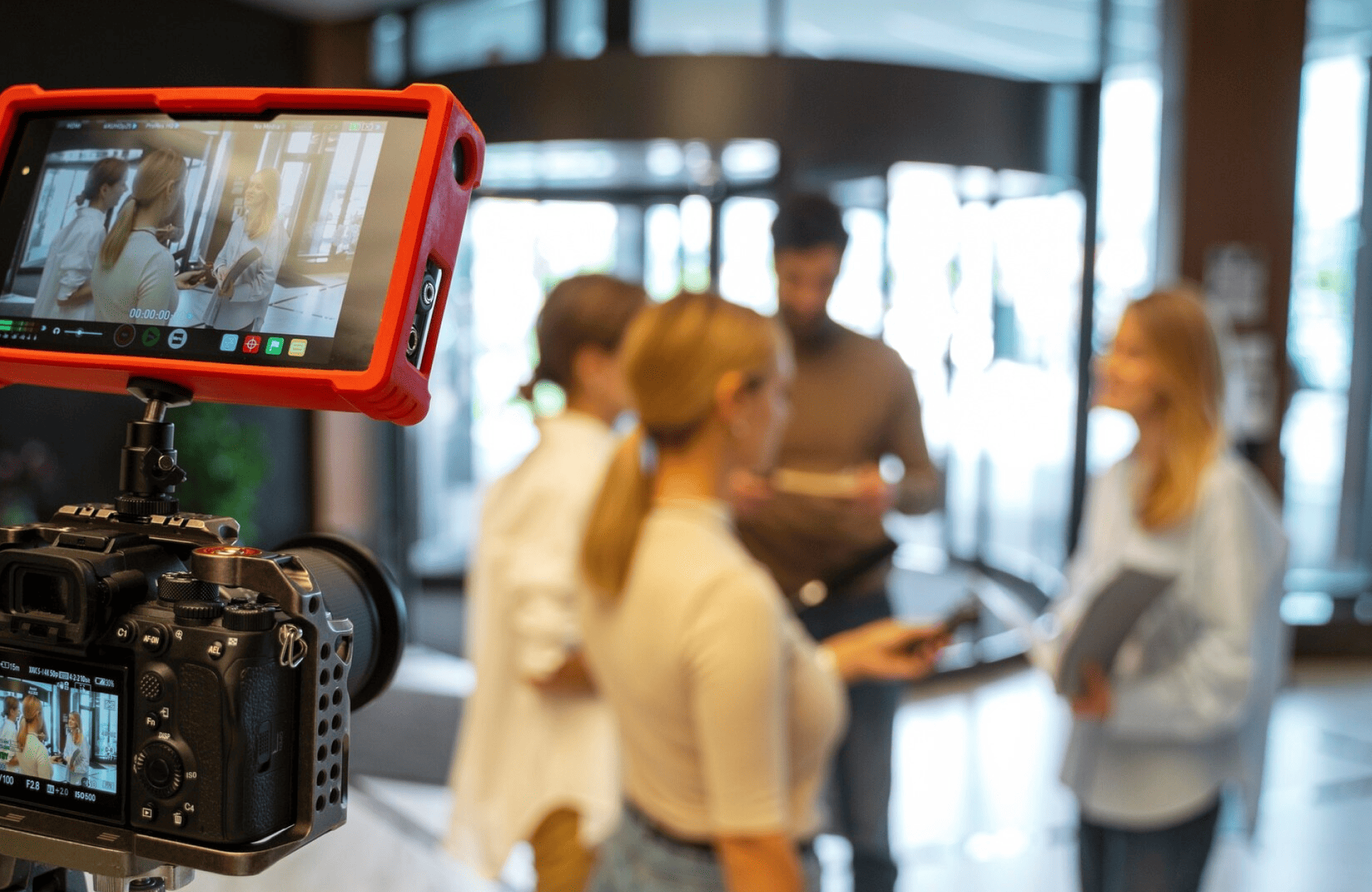 FX Productions Canada A camera from FX Productions Canada records four people standing together indoors, with one holding papers and another holding a microphone, suggesting an interview setting. Toronto Video Production Company