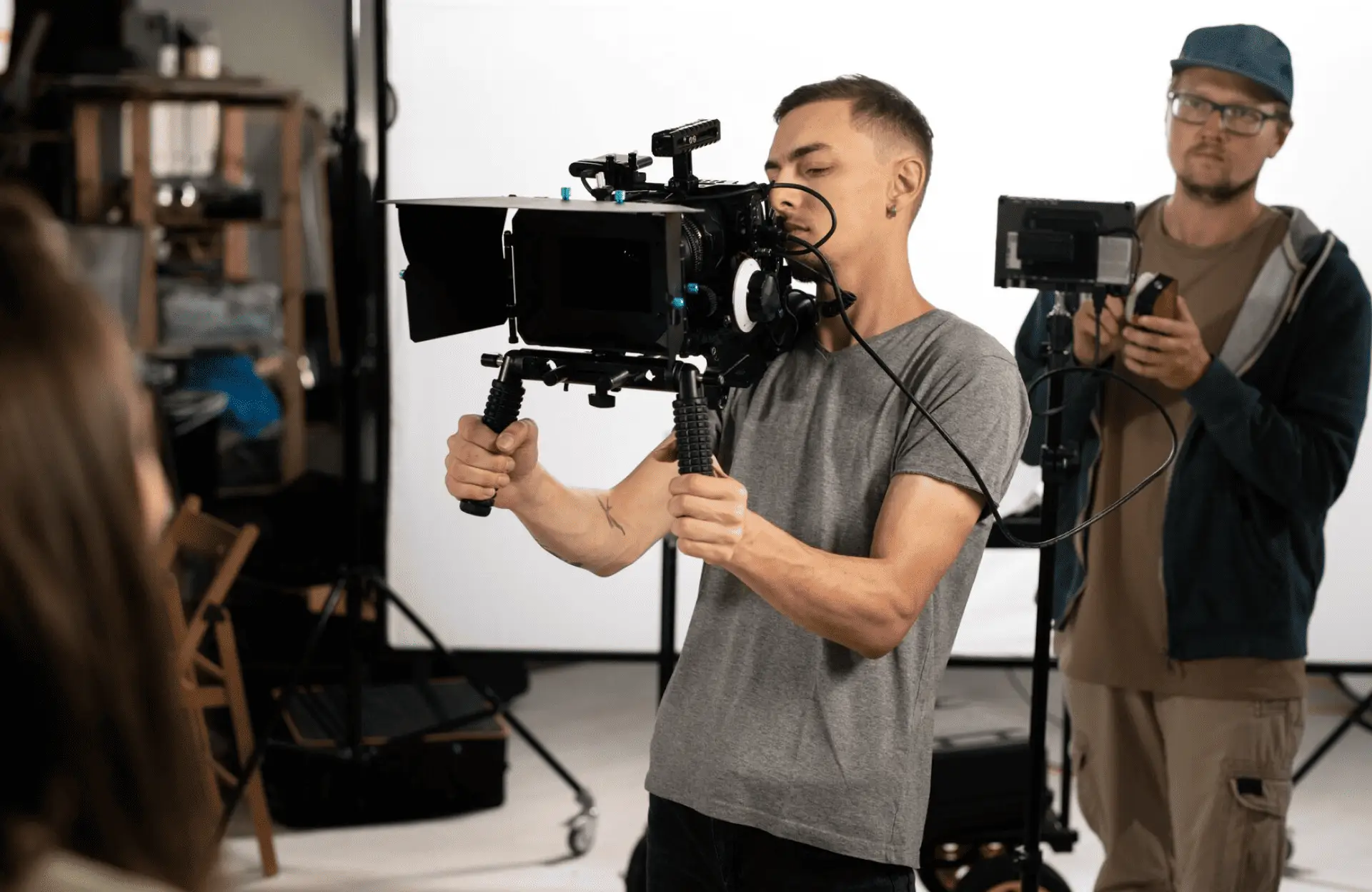 FX Productions Canada A person operates a professional video camera on set, while another stands behind holding audio equipment in a studio—capturing the behind-the-scenes energy of an FX Productions Canada shoot. Toronto Video Production Company