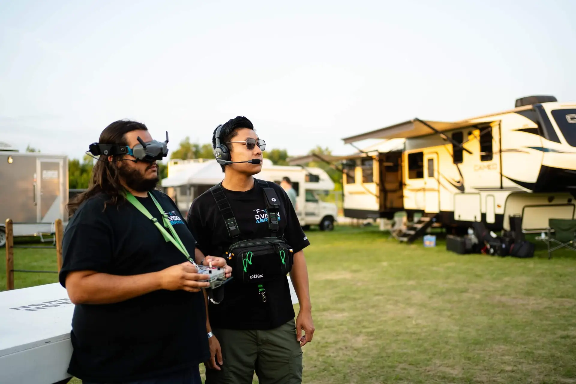 FX Productions Canada Two people operate a drone outdoors near several RVs; one wears FPV goggles and the other uses a headset and remote control, showcasing professional skills from FX Productions Canada, a leading video production company. Toronto Video Production Company