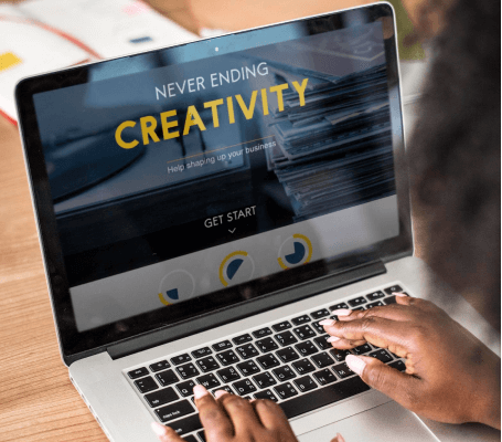 FX Productions Canada Person typing on a laptop displaying a website with the headline "Never Ending Creativity" and a "Get Start" button—showcasing Toronto Video Production excellence. Toronto Video Production Company