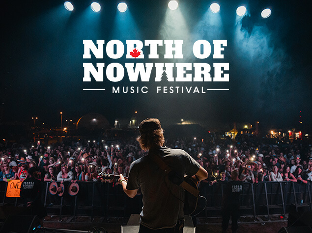 FX Productions Canada Musician playing guitar on stage at night, facing a large crowd under the “North of Nowhere Music Festival” banner—captured by FX Productions Canada, a leading Toronto Video Production company. Toronto Video Production Company