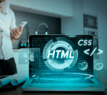 FX Productions Canada A laptop displays digital graphics with "HTML" and "CSS" on the screen; a person holding a phone stands in the blurred background of a modern office at FX Productions Canada, a leading Toronto Video Production company. Toronto Video Production Company