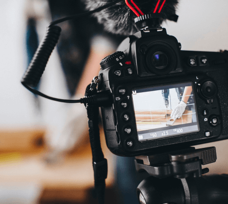 FX Productions Canada Close-up of a camera on a tripod recording a person using a power drill, with the scene visible on the camera's display screen—showcasing the expertise of Toronto Video Production. Toronto Video Production Company