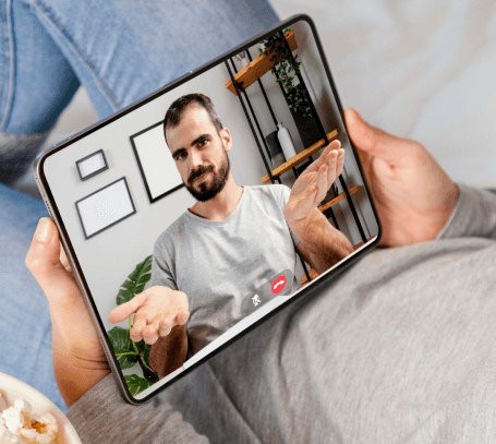 FX Productions Canada A person holds a tablet displaying a video call with a bearded man in a gray shirt gesturing with open hands, showcasing the quality work of FX Productions Canada, a leading Toronto Video Production company. Toronto Video Production Company