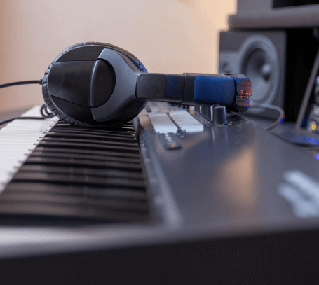 FX Productions Canada A pair of headphones rests on the keys of an electronic keyboard in a music studio at FX Productions Canada, with speakers and other audio equipment in the background. Toronto Video Production Company