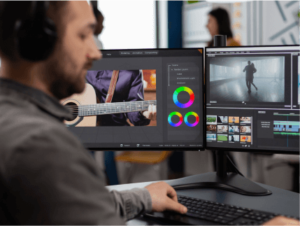 FX Productions Canada A person edits footage on dual monitors, one displaying a guitar and color wheels, the other showing dance clips—a glimpse inside a leading Toronto Video Production company’s creative process. Toronto Video Production Company