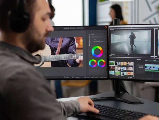 FX Productions Canada Person wearing headphones editing video footage on dual monitors at FX Productions Canada, a leading Toronto Video Production company, with color grading tools and clips visible on the screens. Toronto Video Production Company