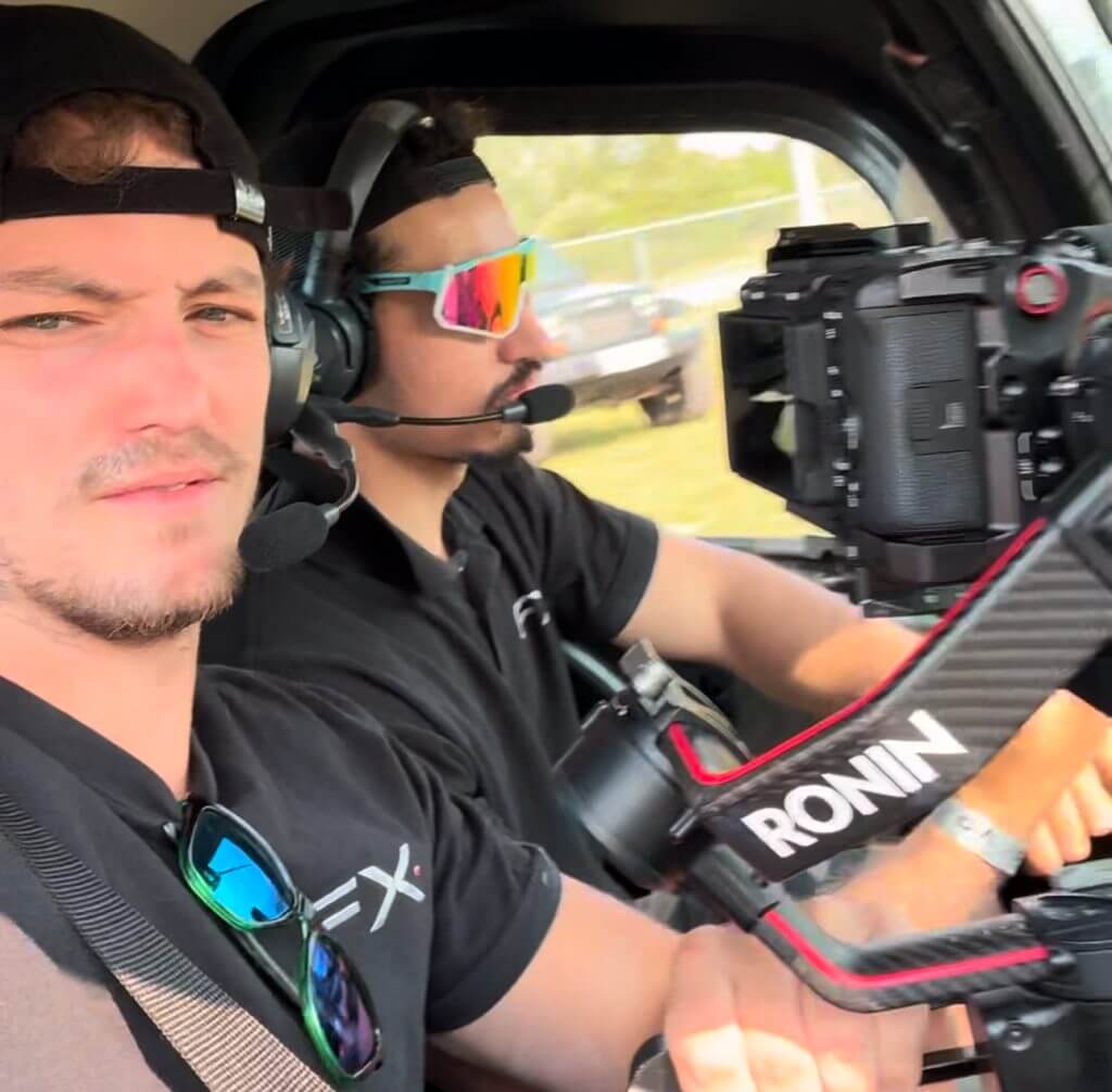 FX Productions Canada Two men in headsets and black shirts operate a Ronin camera rig inside a vehicle; one handles the camera while the other drives—capturing behind-the-scenes action for Toronto Video Production experts. Toronto Video Production Company