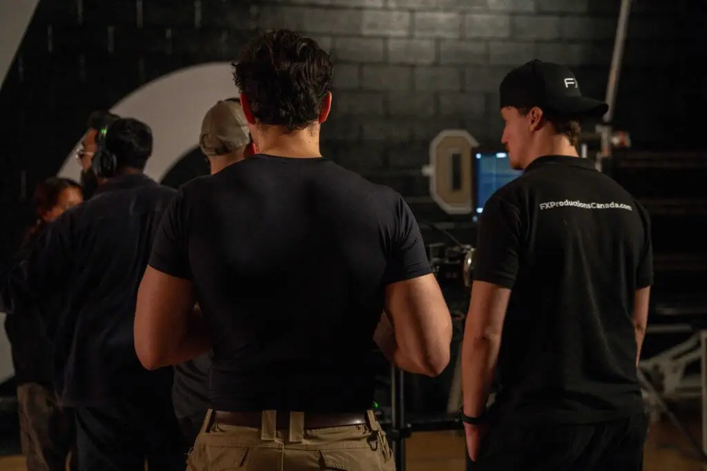 FX Productions Canada Several people stand together in a dimly lit room, some facing computer monitors, suggesting a film or video production setting at FX Productions Canada. Toronto Video Production Company
