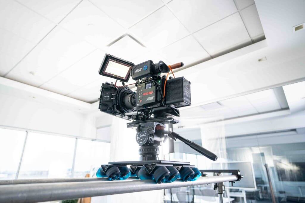 FX Productions Canada A professional video camera mounted on a tripod dolly is positioned on a track in a bright, modern indoor setting, showcasing the expertise of FX Productions Canada, a leading Toronto Video Production company. Toronto Video Production Company