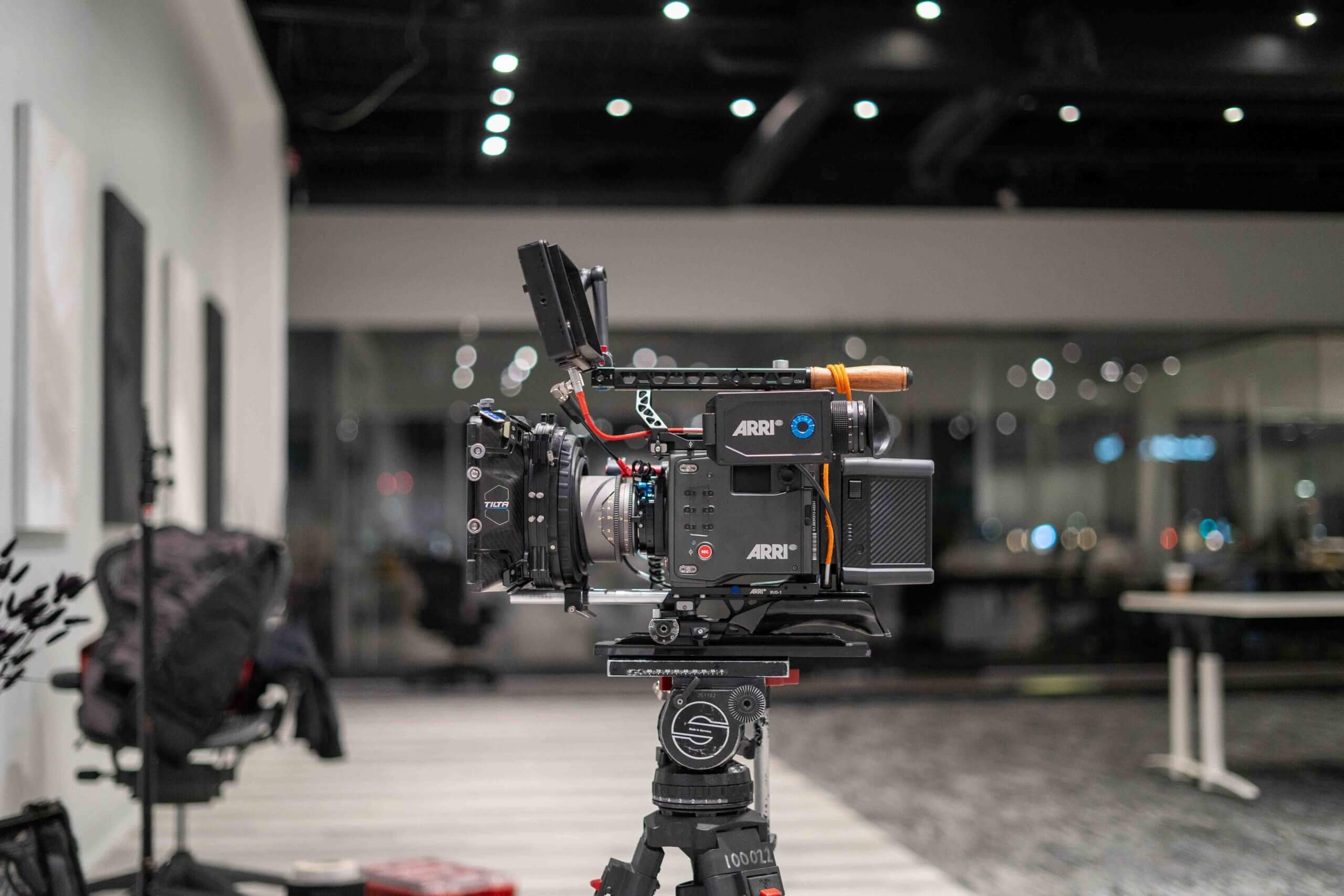 FX Productions Canada A professional ARRI video camera is mounted on a tripod in a modern, well-lit studio with office furniture in the background, showcasing the high standards of FX Productions Canada, a leading Toronto Production Company. Toronto Video Production Company