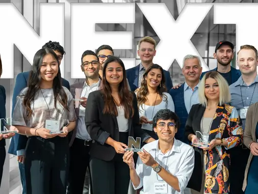 FX Productions Canada A group of professionally dressed people pose indoors, smiling and holding awards, with the word "NEXT" in large letters in the background at FX Productions Canada, a leading Toronto Video Production company. Toronto Video Production Company