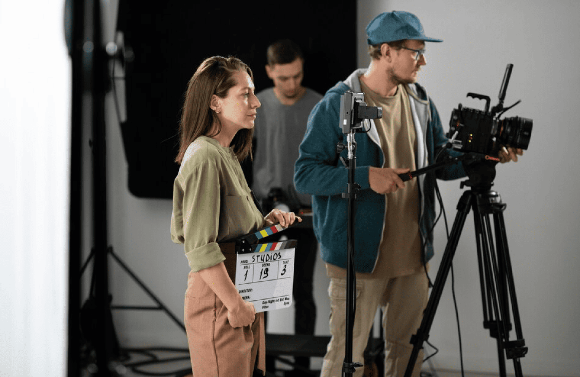 FX Productions Canada Three people work on a film set for FX Productions Canada; one holds a clapperboard, another operates a camera, and a third adjusts equipment in the background. Toronto Video Production Company