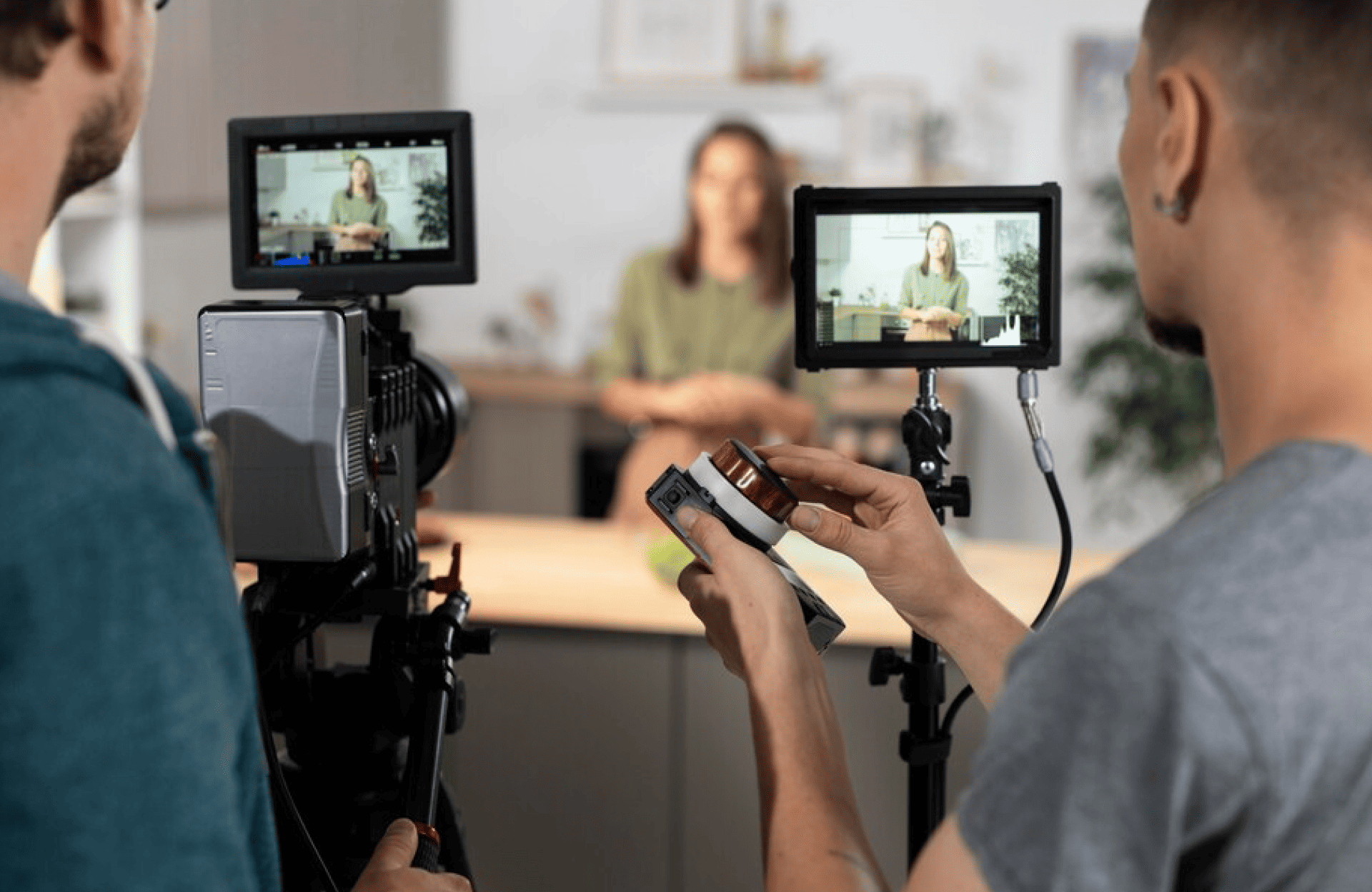 FX Productions Canada Two camera operators from FX Productions Canada film a woman sitting at a table, with the scene displayed on video monitors in a bustling Toronto Production Company studio setting. Toronto Video Production Company