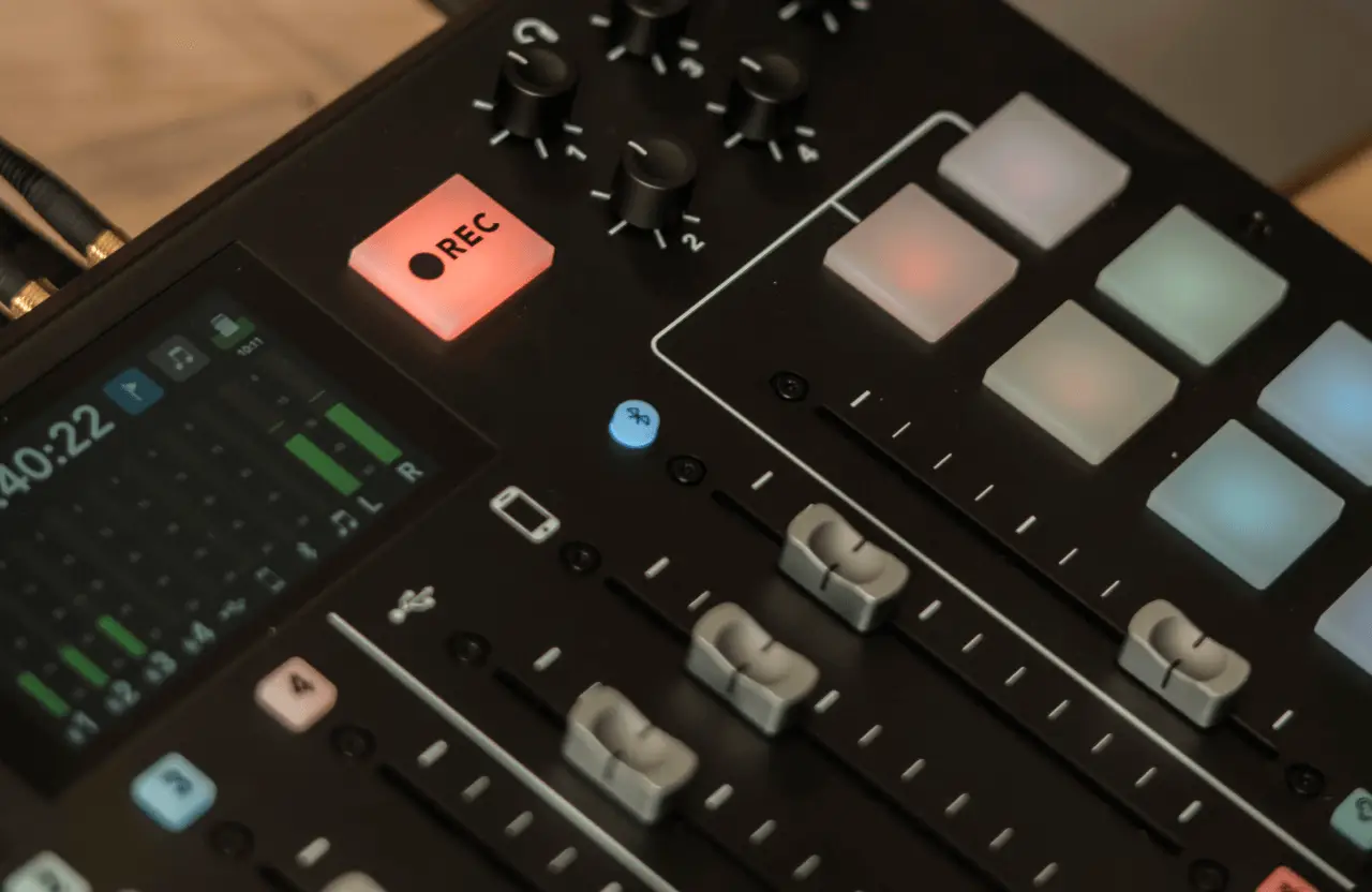 FX Productions Canada Close-up of an audio mixer with sliders, a digital display, illuminated control pads, and a glowing red REC button, highlighting the recording session at FX Productions Canada—a leading Toronto Production Company. Toronto Video Production Company