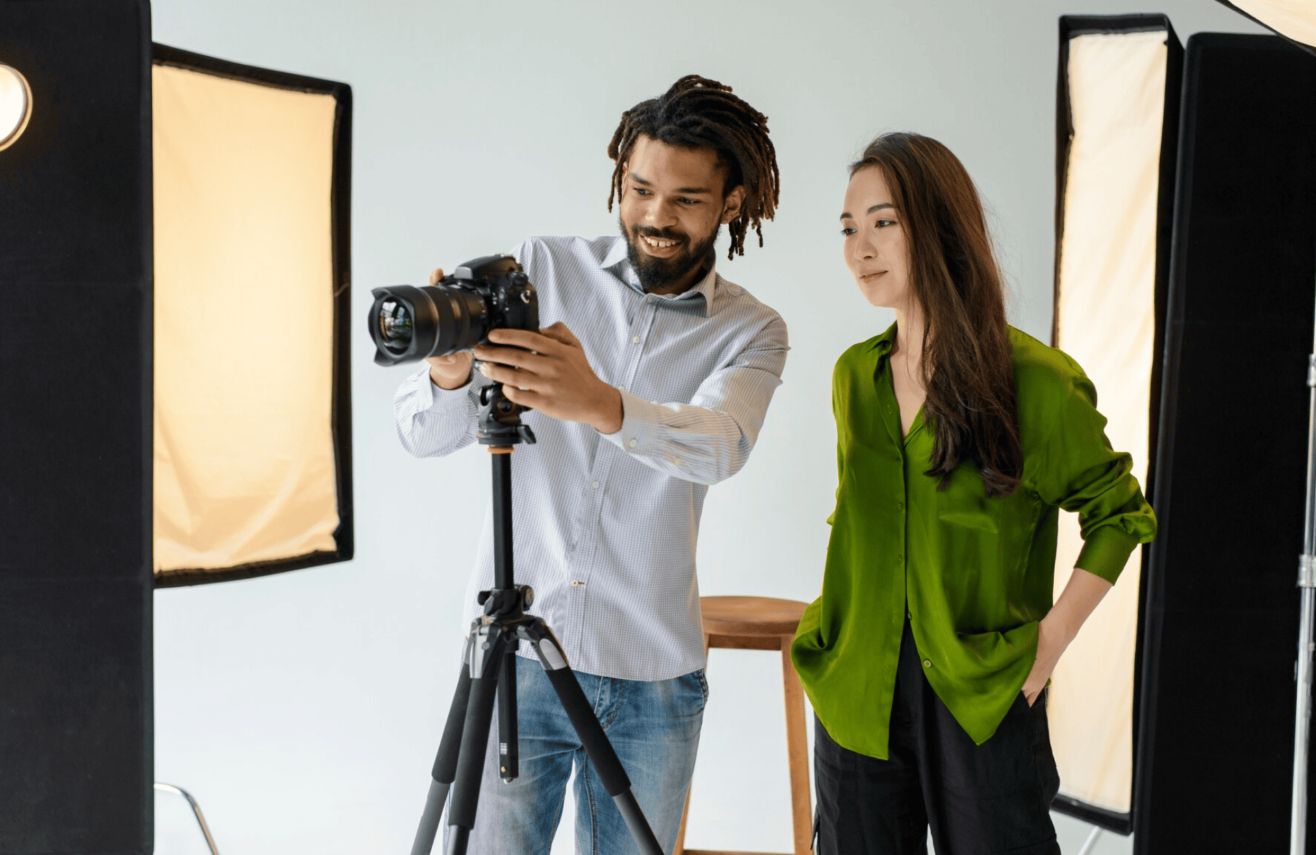 FX Productions Canada Two people stand in a photography studio looking at images on a camera mounted on a tripod, surrounded by studio lights. Toronto Video Production Company