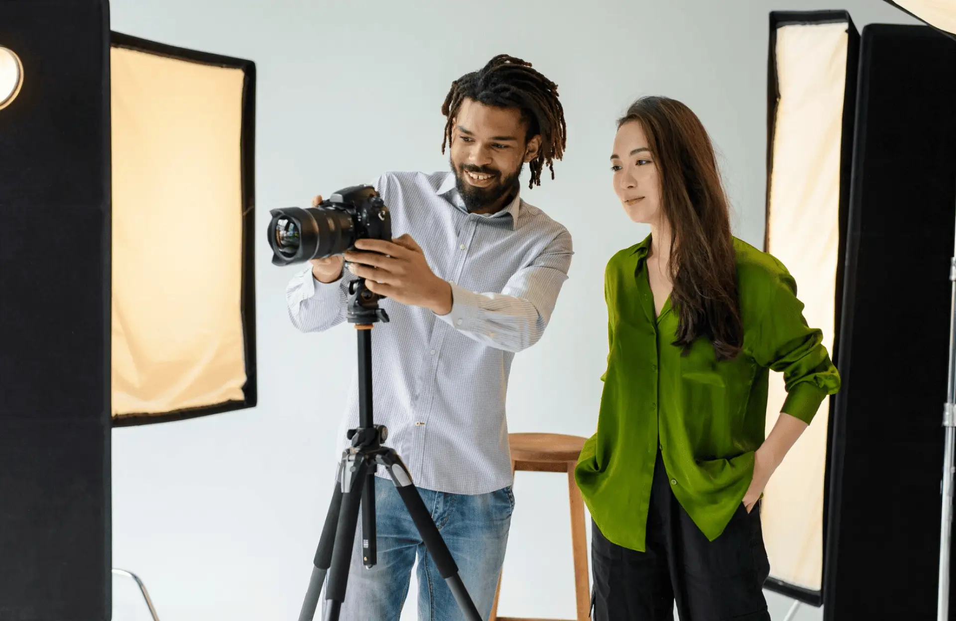 FX Productions Canada Two people stand in a photography studio looking at images on a camera mounted on a tripod, surrounded by studio lights. Toronto Video Production Company