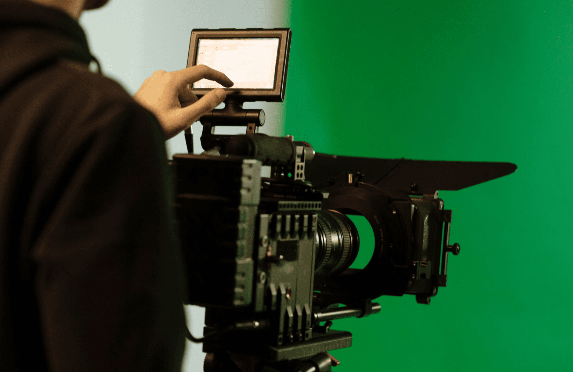 FX Productions Canada A person operates a professional video camera with a monitor in front of a green screen background. Toronto Video Production Company