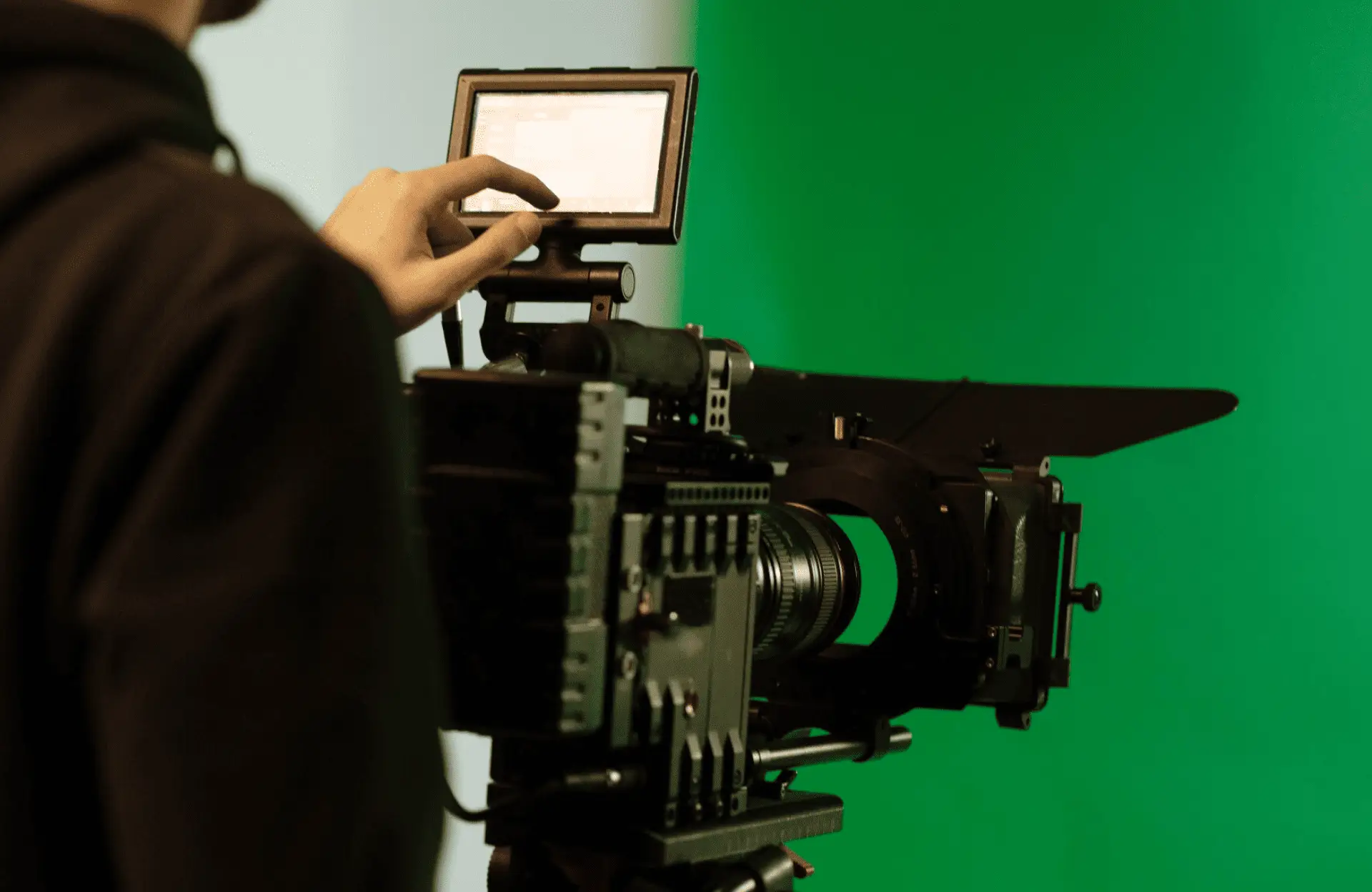 FX Productions Canada A person operates a professional video camera with a monitor in front of a green screen background. Toronto Video Production Company
