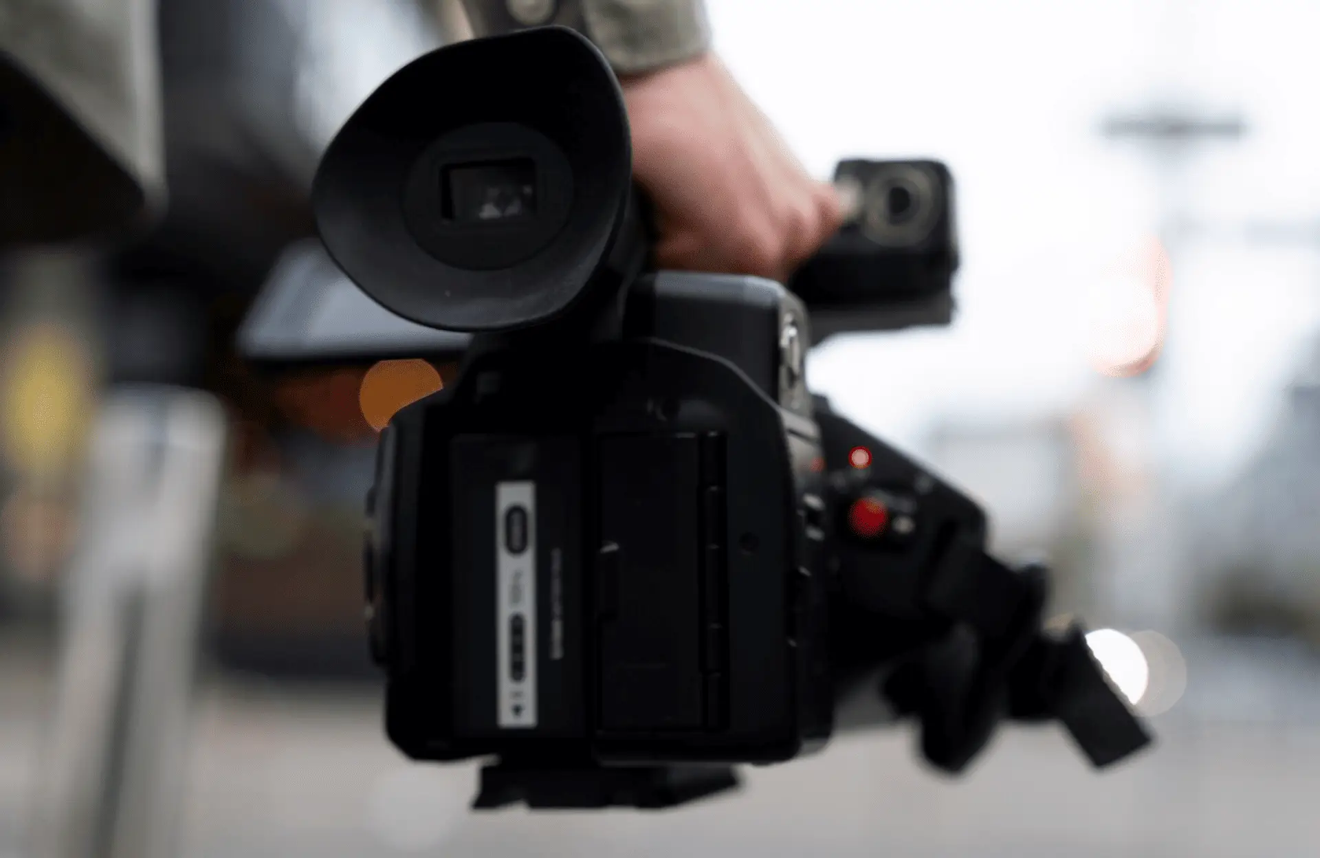 FX Productions Canada A person holds a professional video camera outdoors, with the focus on the camera and a blurred background. Toronto Video Production Company