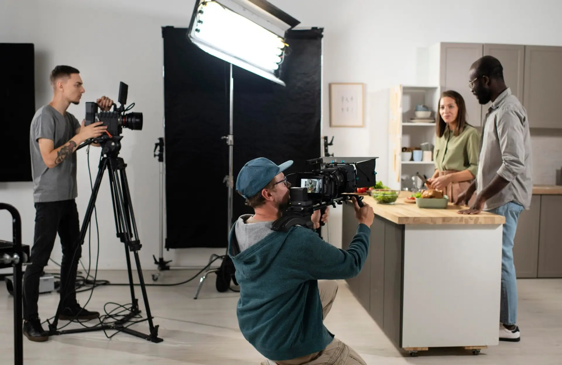 FX Productions Canada A camera crew films a man and a woman preparing food at a kitchen counter on a set with professional lighting and equipment. Toronto Video Production Company