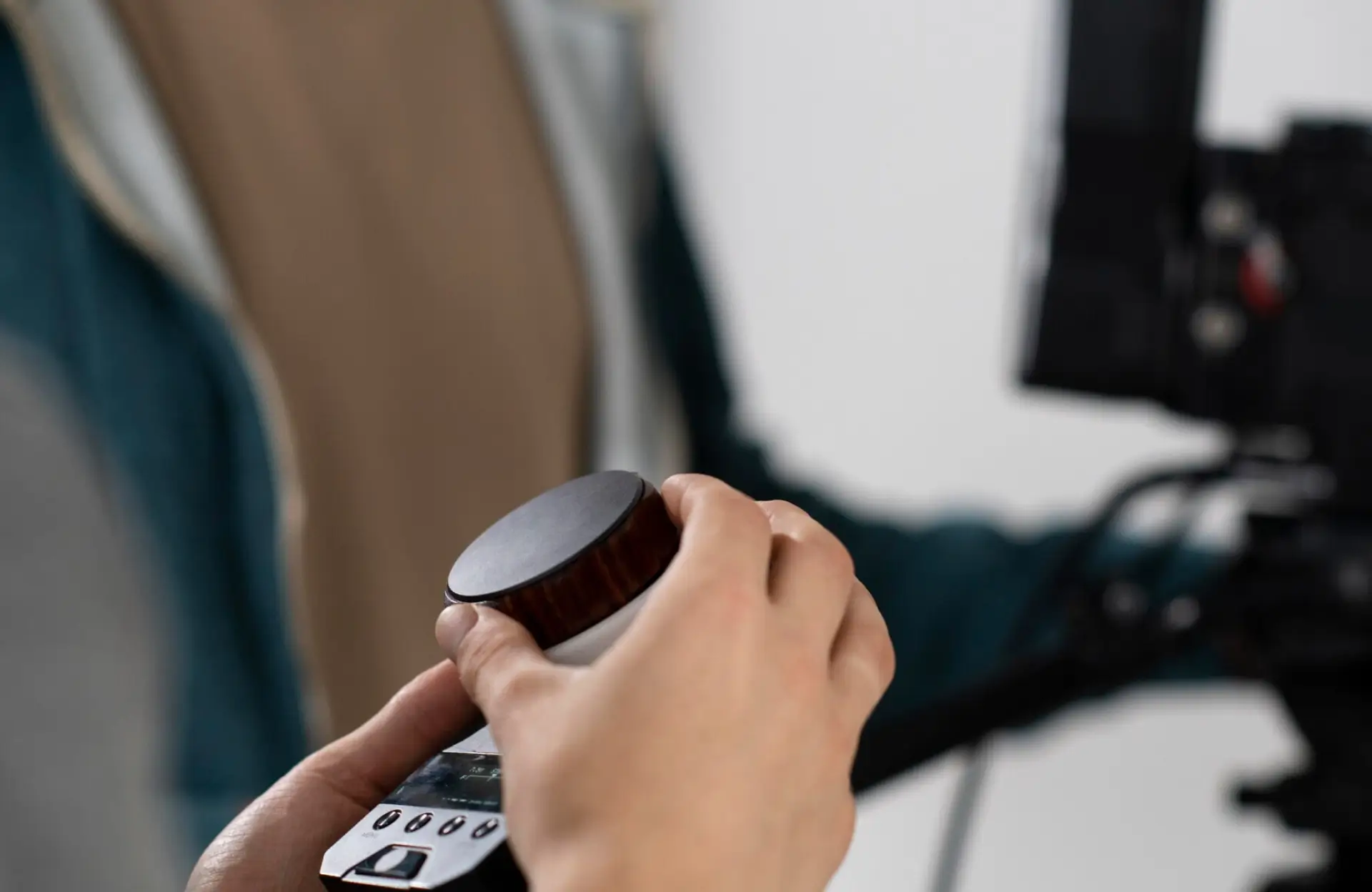 FX Productions Canada A person’s hands adjust a large dial on a control device, with camera equipment visible in the blurred background. Toronto Video Production Company