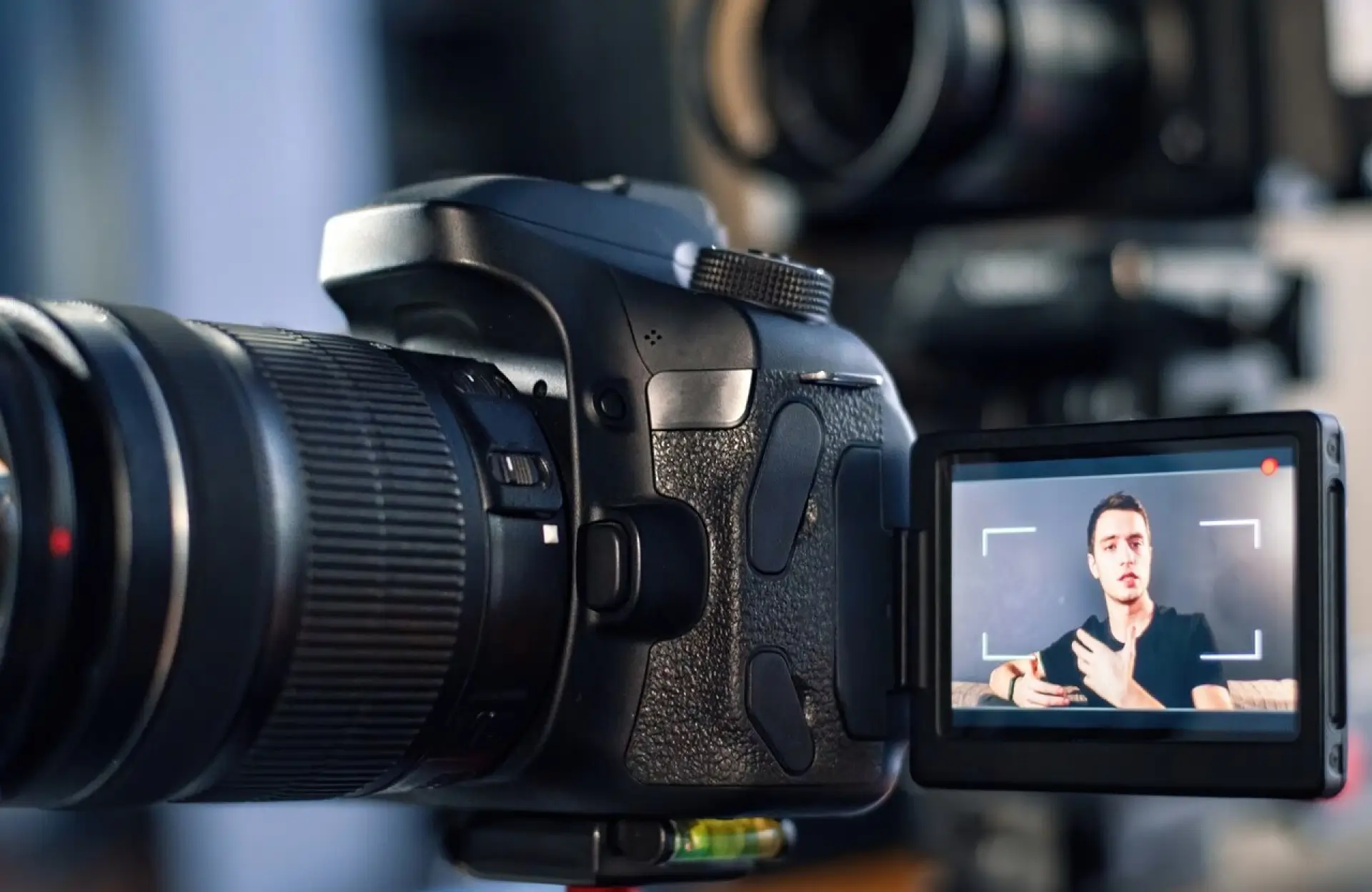 FX Productions Canada A digital camera on a tripod records a man speaking, visible on the camera’s flip-out screen in a close-up shot. Toronto Video Production Company