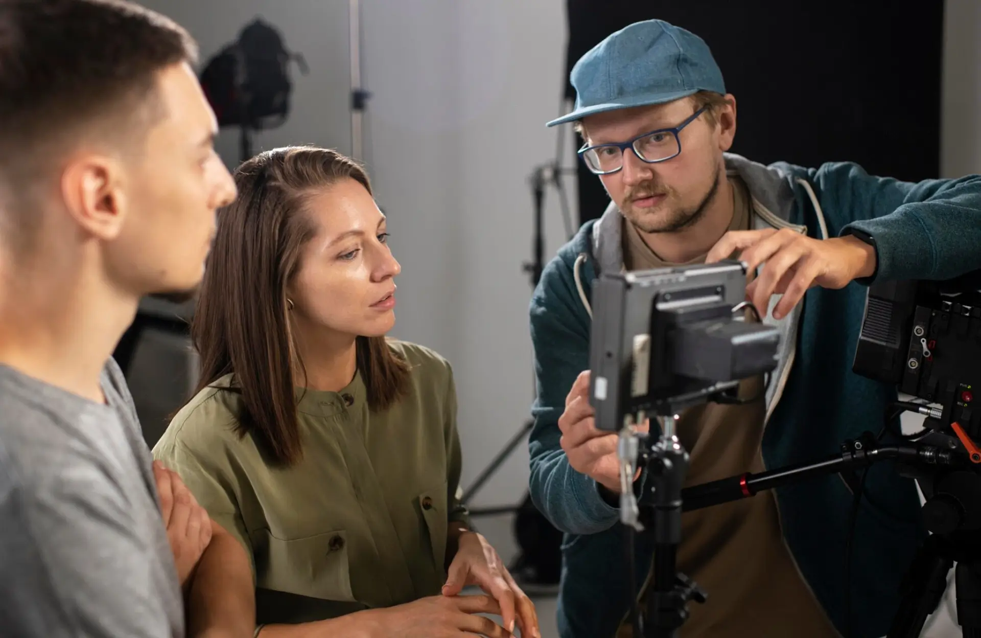 FX Productions Canada Three people stand around a camera setup in a studio, discussing and adjusting the equipment while looking at a monitor. Toronto Video Production Company