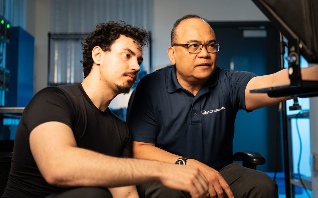 FX Productions Canada Two men focus on a computer monitor in a modern lab setting, with one pointing at the screen and the other observing attentively. Toronto Video Production Company