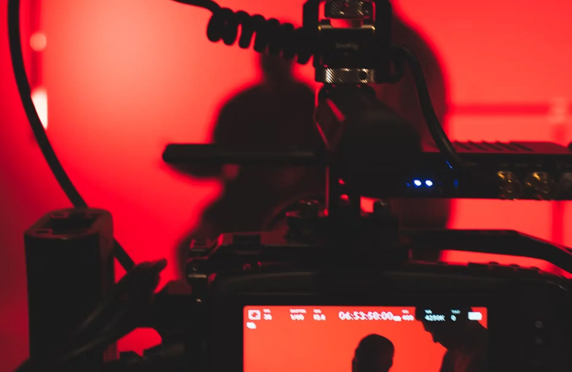 FX Productions Canada A camera setup films a silhouette against a red-lit background, with equipment and the image display screen visible in the foreground. Toronto Video Production Company