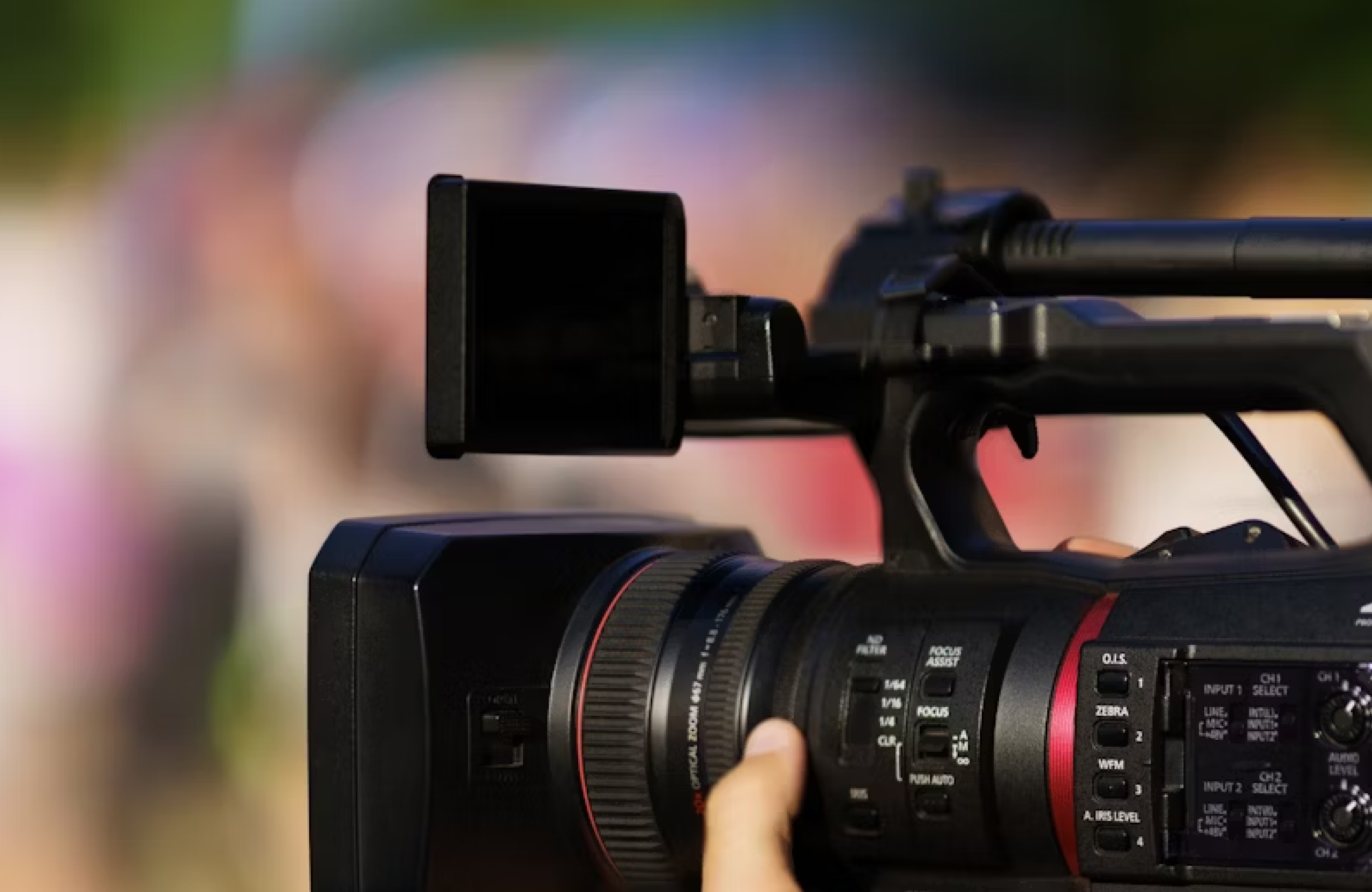 FX Productions Canada A close-up of a professional video camera being operated outdoors, capturing high-quality footage ideal for video marketing, with a blurred background. Toronto Video Production Company