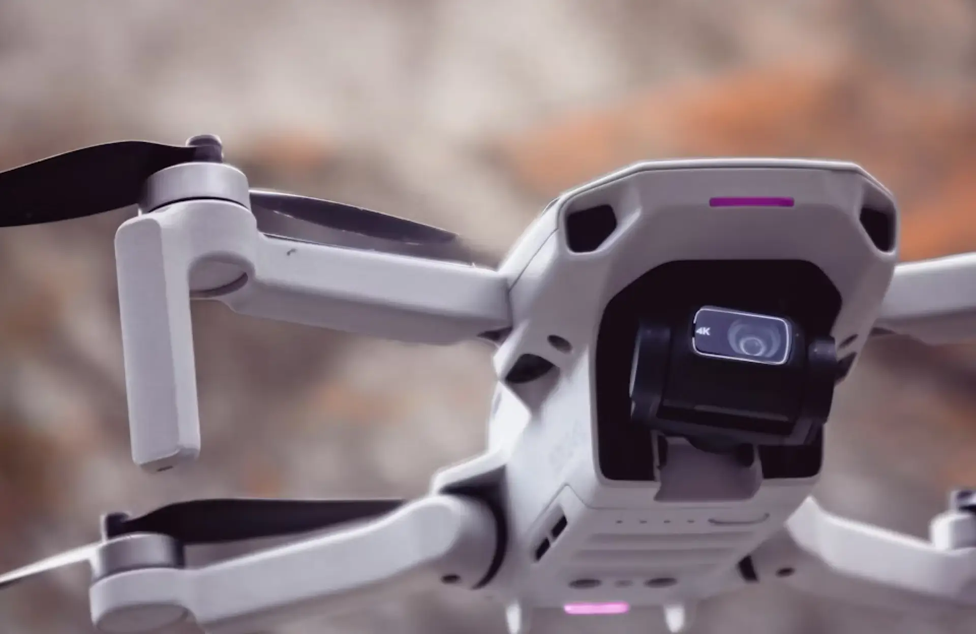FX Productions Canada Close-up of a white quadcopter drone in flight, showing its camera and propellers, with a blurred natural background. Toronto Video Production Company
