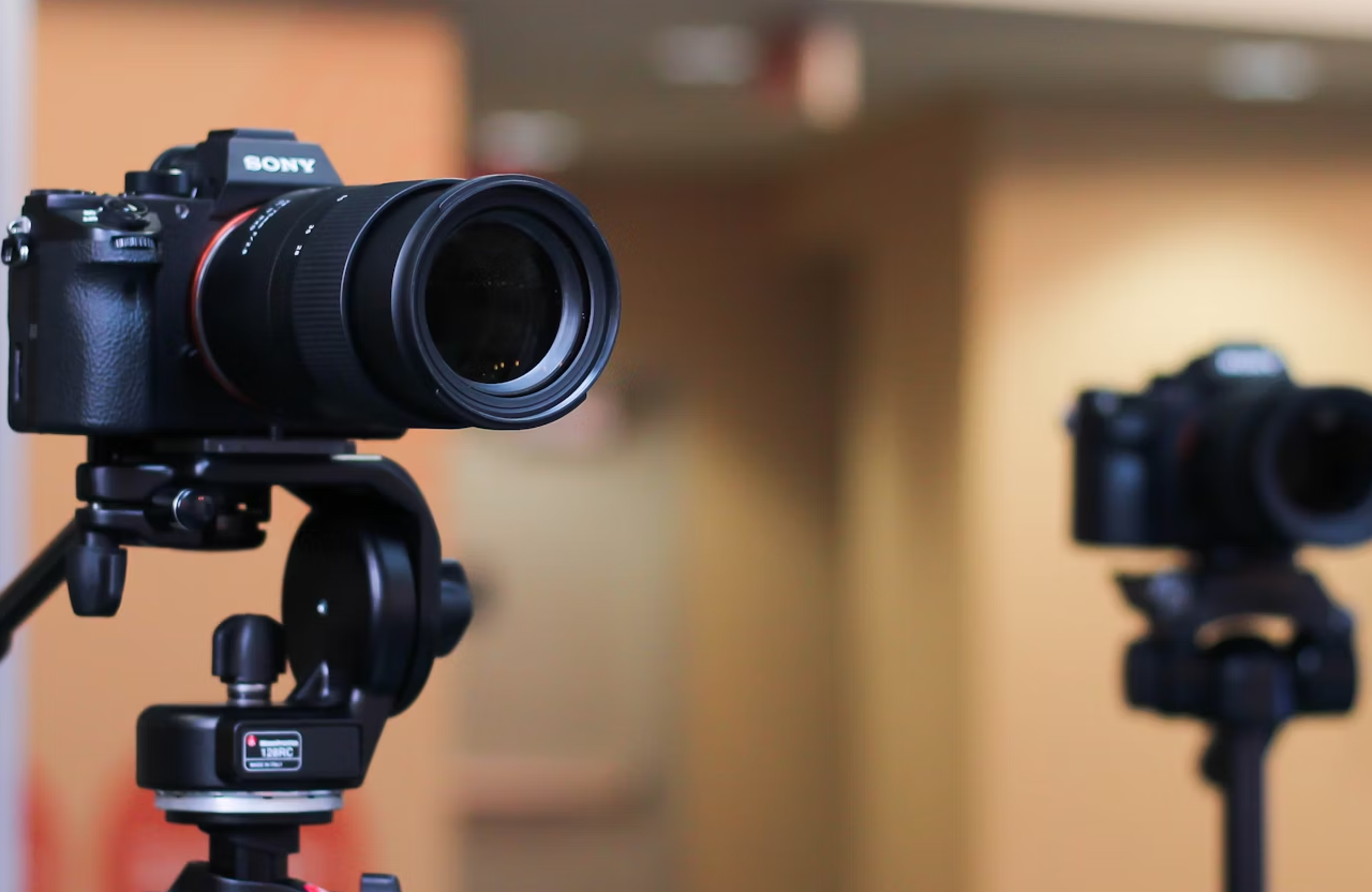 FX Productions Canada Two digital cameras on tripods are set up indoors, with one camera in sharp focus and the other blurred in the background—a perfect scene for advertising agencies in Toronto or for post production Toronto professionals seeking visual precision. Toronto Video Production Company