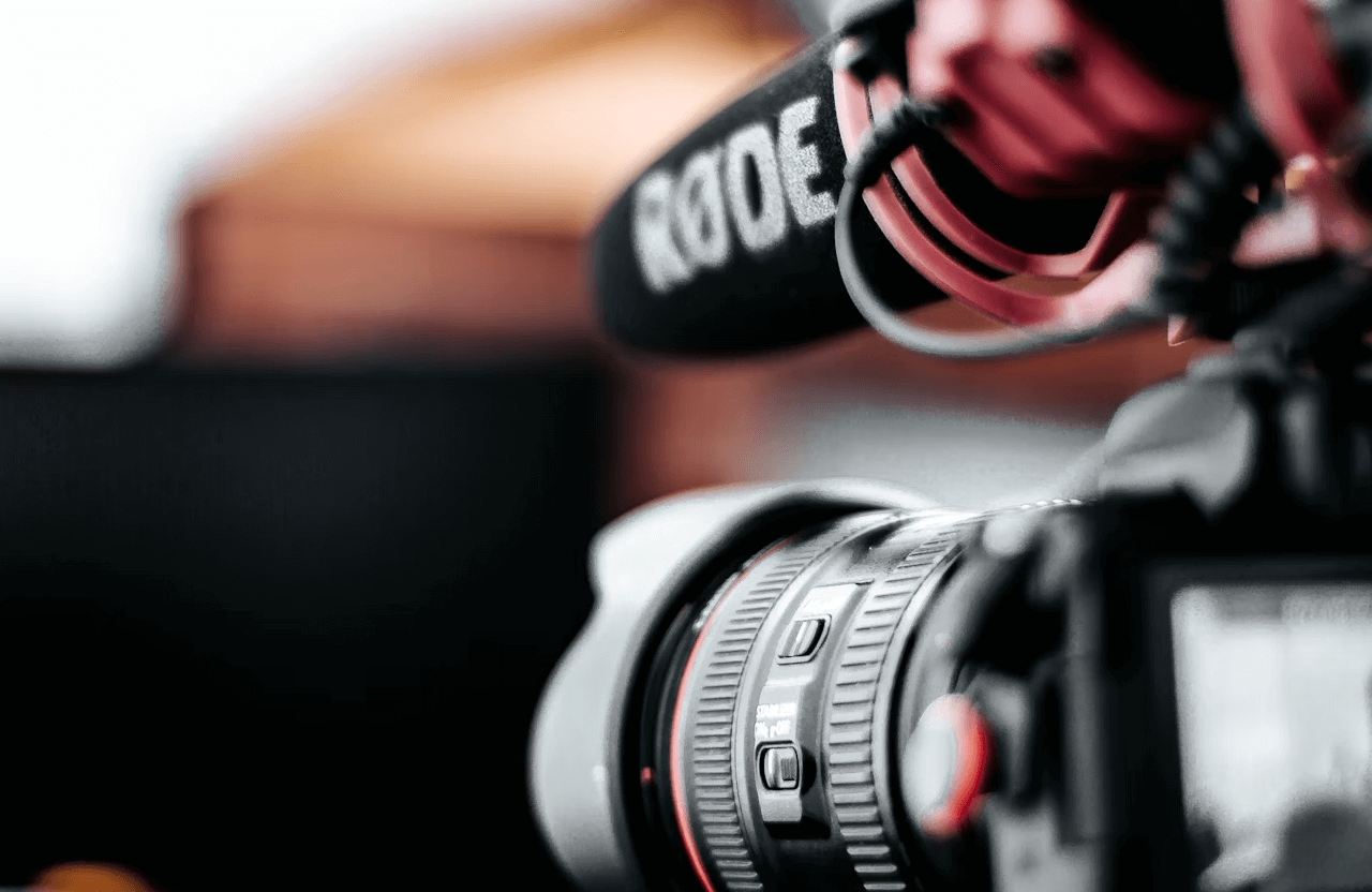 FX Productions Canada Close-up of a professional camera with a large lens and a Rode microphone attached, set up for recording—perfect for cinematic storytelling and high-quality video production. Toronto Video Production Company