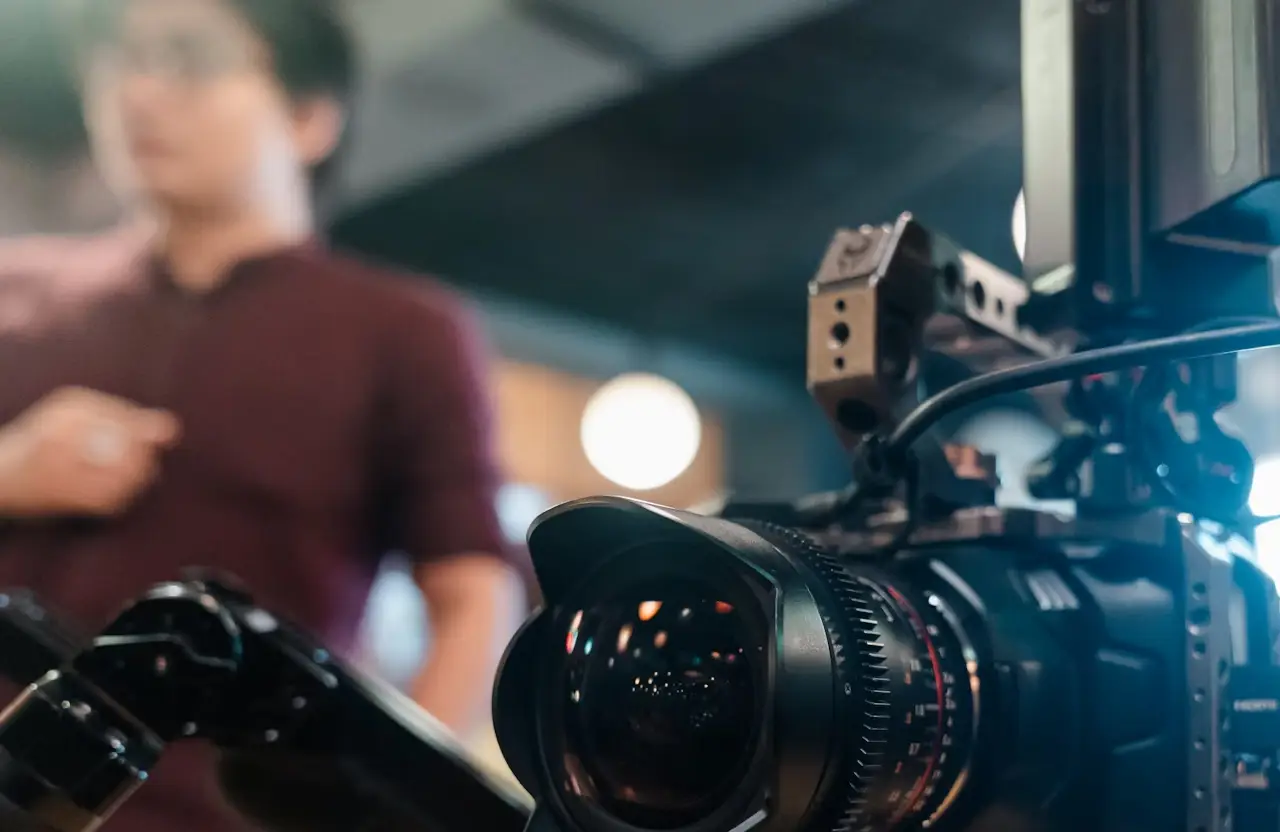 FX Productions Canada A professional video camera is set up in the foreground, capturing a person standing out of focus in the background—perfect for a video production company Toronto seeking authentic brand storytelling. Toronto Video Production Company