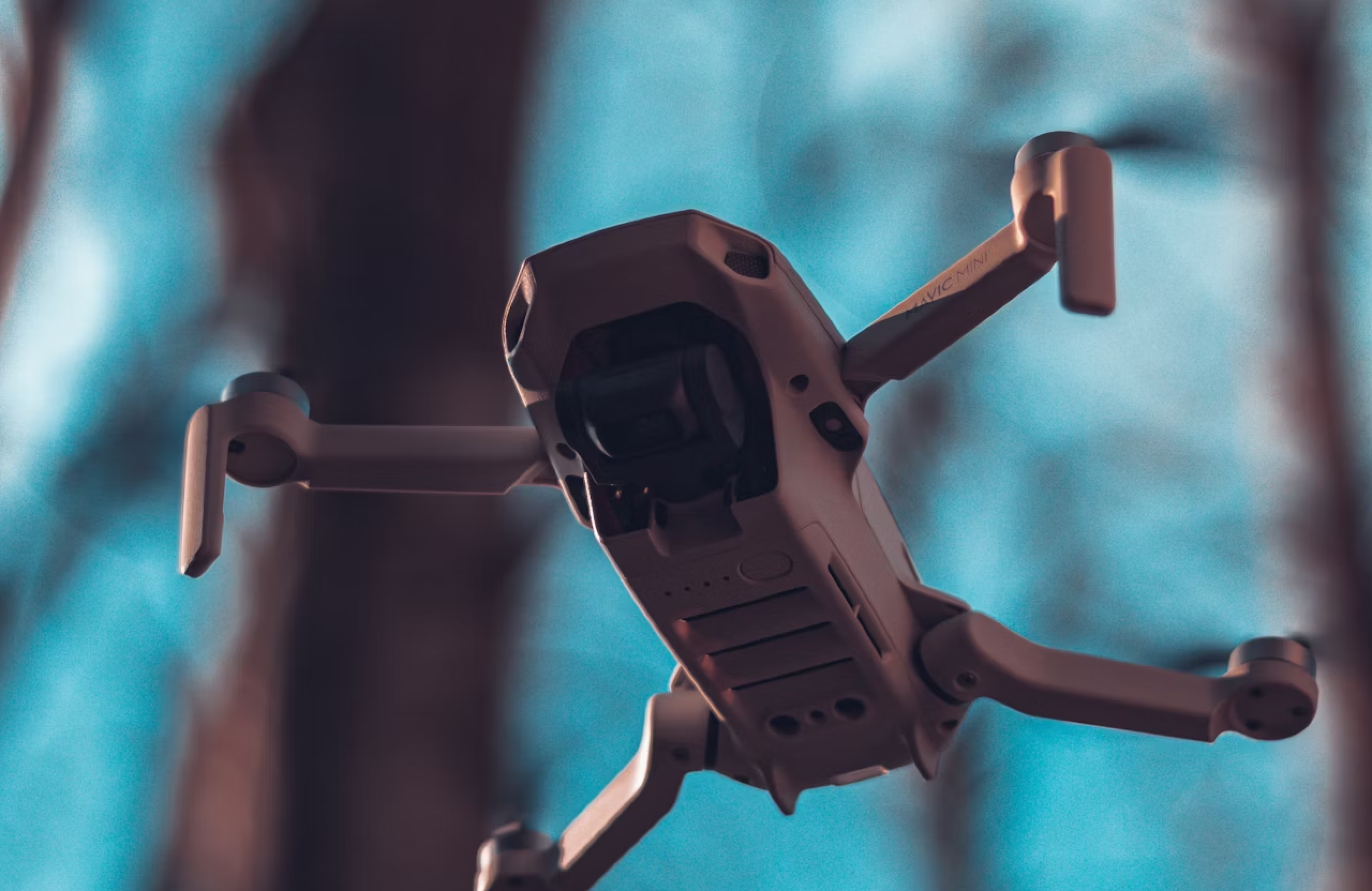 FX Productions Canada A close-up of a drone used for aerial cinematography flying outdoors, with trees and a blue sky visible in the background, showcasing the capabilities achieved through RPAS certification. Toronto Video Production Company