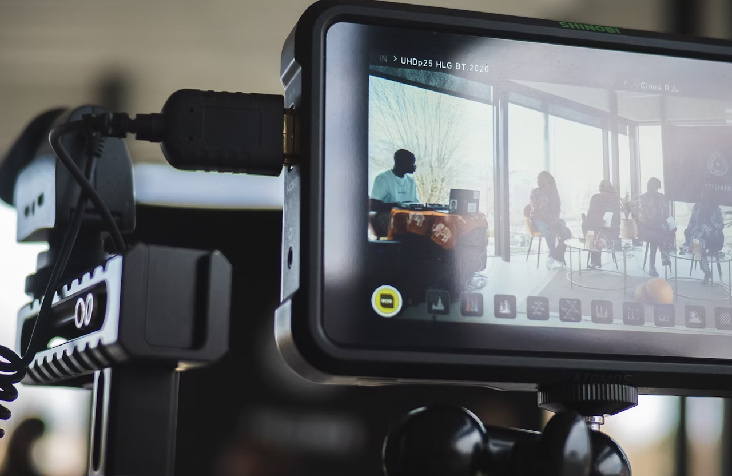 FX Productions Canada A camera monitor displays a live recording of several people seated and talking indoors, with daylight visible through large windows in the background. Toronto Video Production Company